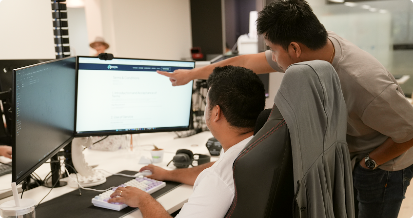 two click click media developers collaborating at a workstation, reviewing a local seo page on screen.