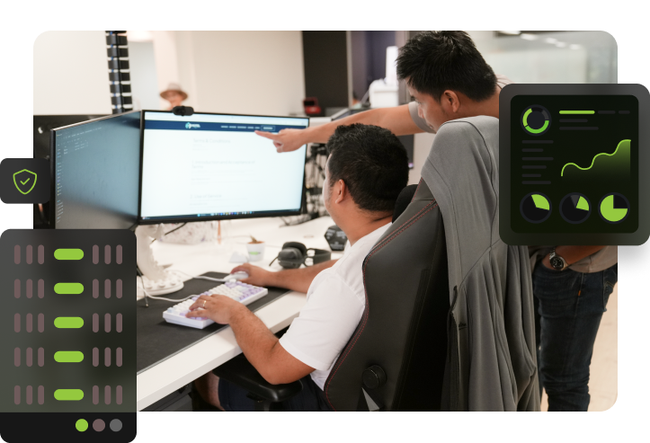 two click click media team members at a dual-monitor workstation reviewing server configuration, with a hosting rack icon, security shield, and performance monitoring dashboard overlaid.